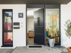 Graue Aluminium-Haustür und Fenster am Eingang eines Einfamilienhauses 